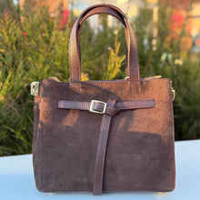 Charger l'image dans la galerie, Brown leather handbag on a table with a blurred outdoor background
