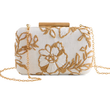Cargar imagen en el visor de la galería, White clutch bag with gold floral embroidery and chain strap on a white background
